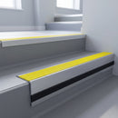 Yellow Castellated insert in a cut to size 66x55mm aluminium stair nosing with 13mm black riser highlight, fitted to interior steps