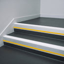 White Castellated insert in a cut to size 66x55mm aluminium stair nosing with 13mm Yellow riser highlight, fitted to interior steps
