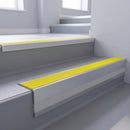 Yellow Castellated insert in a cut to size 66x55mm aluminium stair nosing with 13mm Polar Grey riser highlight, fitted to interior steps
