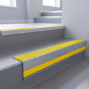 Yellow Castellated insert in a cut to size 66x55mm aluminium stair nosing with 13mm Yellow riser highlight, fitted to interior steps