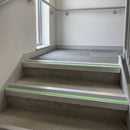 Photoluminescent aluminium stair nosing with midnight grey insert fitted along concrete steps in a commercial stairwell
