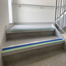 Square edge aluminium stair nosing with cobalt blue PVC insert and green photoluminescent strip fitted on leisure centre stairs