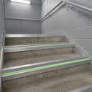 Square edge aluminium stair nosing with dolphin grey PVC insert and green photoluminescent strip fitted on concrete car park stairs