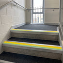 Square edge aluminium stair nosing with yellow PVC insert and green photoluminescent strip fitted on college stairs