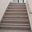 Aluminium stair nosings with brown anti-slip PVC inserts fitted to grey tiled steps indoors