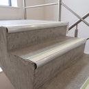Canvas insert 70x40mm bullnose aluminium stair nosing with photoluminescent strip fitted along two concrete steps in a commercial stairwell