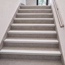 Aluminium stair nosings with white anti-slip PVC inserts fitted to grey tiled steps in an internal stairwell