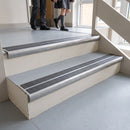 Mill finish aluminium bullnose stair nosing with twin premium black inserts fitted to a school stairwell step
