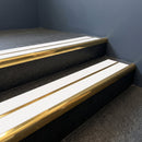 Mirrorflect gold aluminium bullnose stair nosing with twin white inserts fitted to a hotel lobby step
