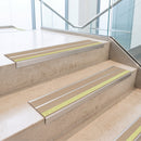 Beige double insert 91x32mm aluminium stair nosing fitted to concrete office steps with a green photoluminescent nose strip