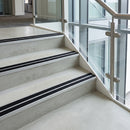 Black double insert 91x32mm aluminium stair nosings fitted to concrete office steps, two anti-slip bands split by a mill aluminium rib