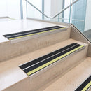 Black double insert 91x32mm aluminium stair nosings fitted to concrete office steps, green photoluminescent strip along each step edge