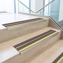 Brown double insert 91x32mm aluminium stair nosing fitted to concrete office steps with a green photoluminescent nose strip