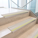 Canvas double insert 91x32mm aluminium stair nosing fitted to concrete office steps with a green photoluminescent nose strip