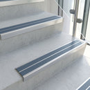 Cobalt Blue double insert 91x32mm aluminium stair nosing fitted to concrete office steps in a glazed stairwell
