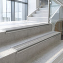 Dolphin Grey double insert 91x32mm aluminium stair nosing fitted to concrete office steps in a glazed stairwell