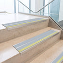 Ice Grey double insert 91x32mm aluminium stair nosing fitted to concrete office steps with a green photoluminescent nose strip
