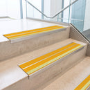 Yellow double insert 91x32mm aluminium stair nosing fitted to concrete office steps with a green photoluminescent nose strip