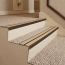 Dark bronze aluminium chevron stair nosing with twin beige inserts fitted to two carpeted hotel corridor steps