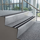 Mill finish aluminium chevron stair nosing with twin premium black inserts fitted to two carpeted office stairwell steps