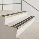 Satin gold aluminium chevron stair nosing with twin dark grey inserts fitted to two carpeted foyer steps