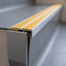 Close-up of the double insert chevron stair nosing end showing the flush inserts and angled riser face