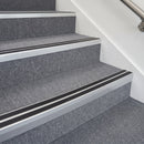 Satin silver double insert chevron stair nosing with black inserts fitted on grey carpeted office stairs