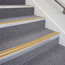 Mill finish double insert chevron stair nosing with yellow inserts fitted on grey carpeted stairs