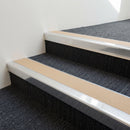 Bright polished aluminium stair nosing with Sahara insert fitted to charcoal carpet tile on a shopping centre stair