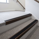 Dark bronze aluminium stair nosing with Premium Black insert fitted to light carpeted office reception stairs