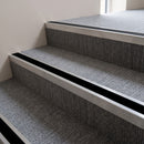 Mill finish aluminium stair nosing with Premium Black insert fitted to carpeted steps in a school stairwell
