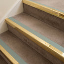 Mirrorflect gold aluminium stair nosing with Sage Green insert fitted to taupe carpet on a care home stair