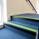 Satin black aluminium stair nosing with Apple Green insert fitted to blue carpet tile on a school corridor stair