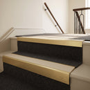 Satin gold aluminium stair nosing with Beige insert fitted to charcoal carpet on a boutique hotel stair