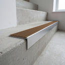 Slimline raked back 59x30mm aluminium stair nosing with a fawn sandy-brown ribbed PVC insert, on a satin aluminium bar, fitted directly to a bare concrete step