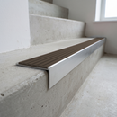 Slimline raked back 59x30mm aluminium stair nosing with a granite taupe-brown ribbed PVC insert, on a satin aluminium bar, fitted directly to a bare concrete step