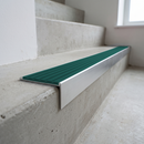 Slimline raked back 59x30mm aluminium stair nosing with a jade teal-green ribbed PVC insert, on a satin aluminium bar, fitted directly to a bare concrete step
