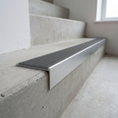 Slimline raked back 59x30mm aluminium stair nosing with a light grey smooth textured PVC insert with no ribs, on a satin aluminium bar, fitted directly to a bare concrete step
