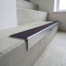Slimline raked back 59x30mm aluminium stair nosing with a dark nimbus lilac-grey ribbed PVC insert, on a satin aluminium bar, fitted directly to a bare concrete step