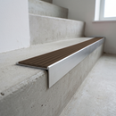 Slimline raked back 59x30mm aluminium stair nosing with a dark peat brown ribbed PVC insert, on a satin aluminium bar, fitted directly to a bare concrete step