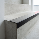 Slimline raked back 59x30mm aluminium stair nosing with a pale polar grey smooth textured PVC insert with no ribs, on a black anodised bar, fitted directly to a bare concrete step