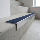 Slimline raked back 59x30mm aluminium stair nosing with a regency slate-blue ribbed PVC insert, on a satin aluminium bar, fitted directly to a bare concrete step
