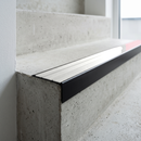 Slimline raked back 59x30mm aluminium stair nosing with a white ribbed PVC insert, on a black anodised bar, fitted directly to a bare concrete step