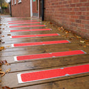 Red 115 x 1000mm anti-slip plates screwed across a timber fire exit ramp outside a school
