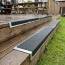 Black grit aluminium nosing plates fitted to decking steps in a pub beer garden