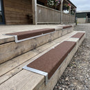 Brown grit aluminium nosing plates fitted to timber steps at a farm shop veranda