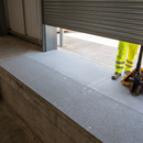 Grey anti-slip GRP sheets fixed across a concrete loading bay edge with an operative and a pallet truck