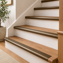 Antique bronze 89mm bull nose stair nosings on oak treads beside a potted olive tree