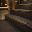 Antique bronze ridged stair nosings on dark charcoal steps in a hotel lobby