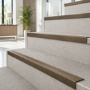 Antique bronze ridged stair nosings on light stone steps in a bright modern interior